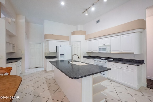 kitchen with a kitchen island with sink, white cabinetry, sink, and white appliances