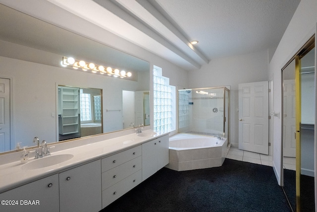 bathroom with tile patterned flooring, vanity, a textured ceiling, and plus walk in shower