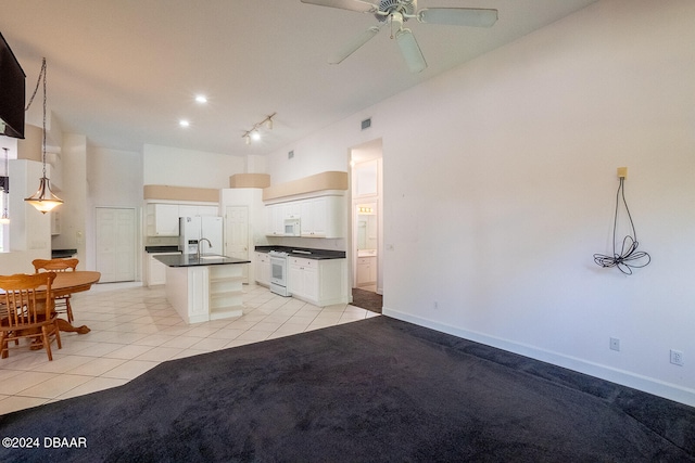 kitchen featuring light tile patterned floors, an island with sink, white cabinetry, white appliances, and decorative light fixtures