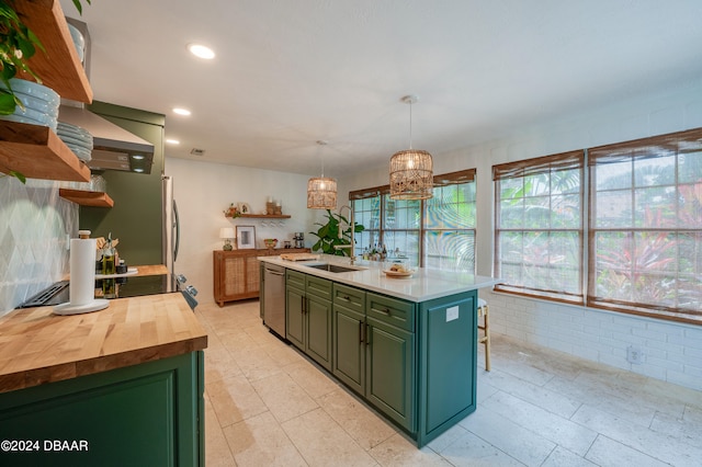 kitchen with a breakfast bar, hanging light fixtures, stainless steel dishwasher, a chandelier, and a kitchen island with sink