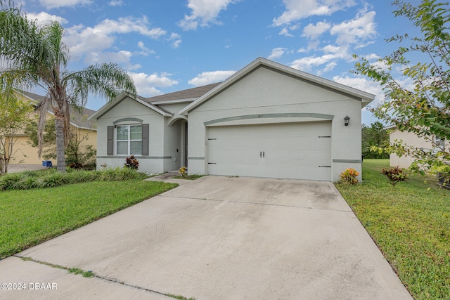 single story home featuring a front lawn and a garage