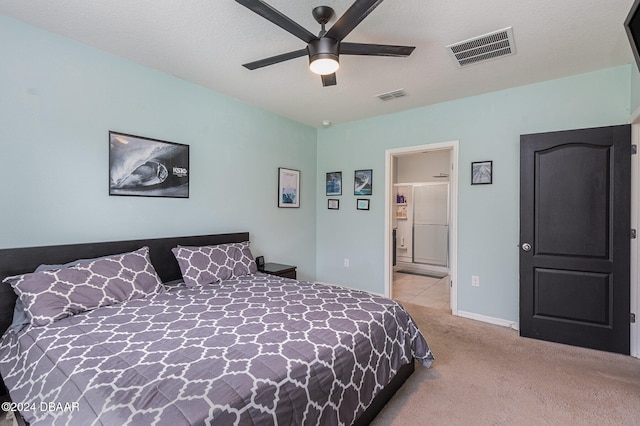 bedroom featuring a textured ceiling, light colored carpet, and ceiling fan