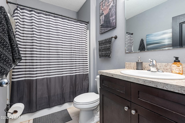 bathroom featuring toilet, vanity, a textured ceiling, and tile patterned flooring