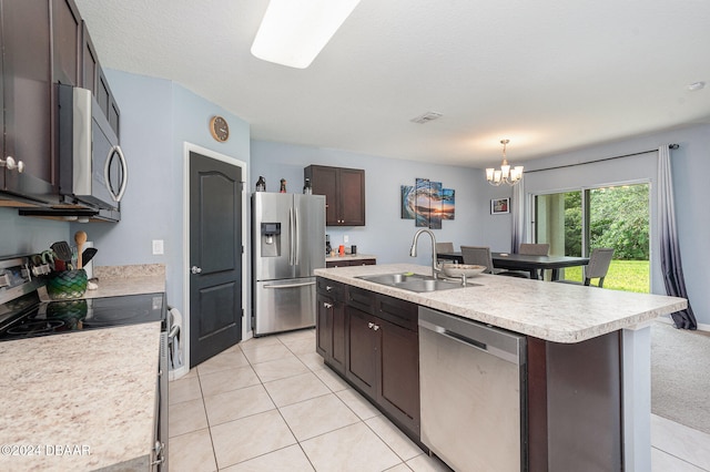 kitchen featuring a center island with sink, stainless steel appliances, dark brown cabinets, pendant lighting, and sink