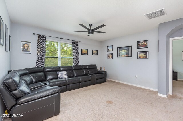 carpeted living room with ceiling fan