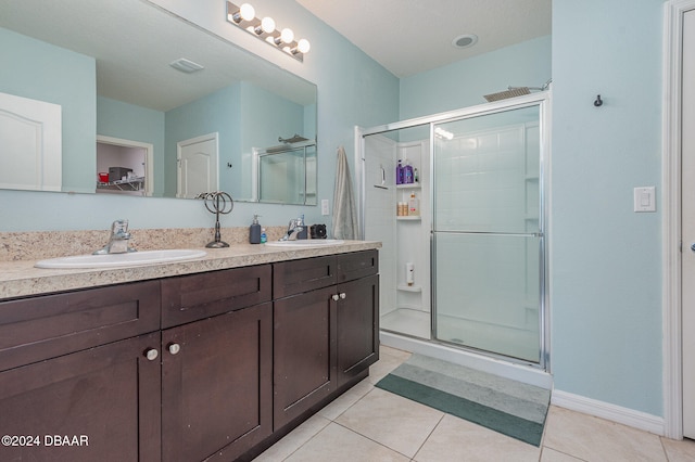 bathroom featuring vanity, a shower with door, and tile patterned floors