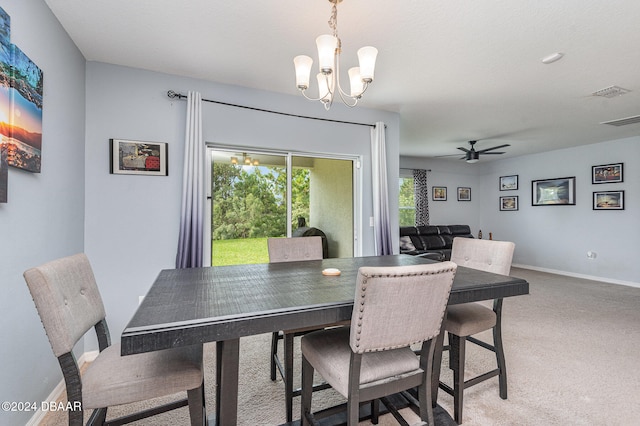 dining area featuring ceiling fan with notable chandelier and light colored carpet