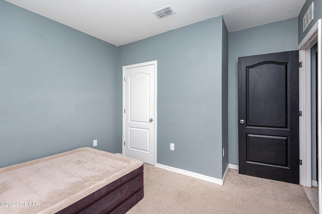 carpeted bedroom featuring a textured ceiling