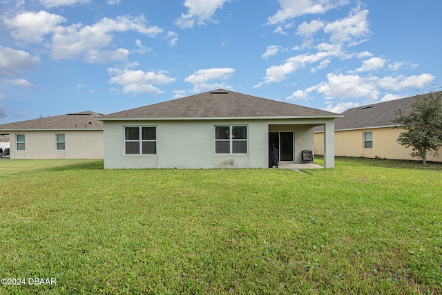 rear view of house with a patio and a yard