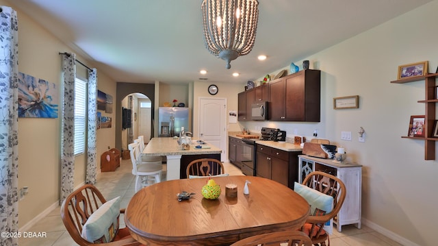 551 Armoyan Way, New Smyrna Beach, FL 32168 - dining area with light tile patterned flooring, arched walkways, recessed lighting, and a chandelier