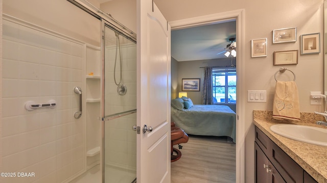 551 Armoyan Way, New Smyrna Beach, FL 32168 - ensuite bathroom with a stall shower, vanity, a ceiling fan, and wood finished floors