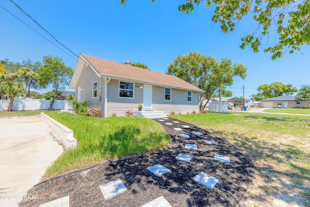 view of front facade with a front yard and a storage unit