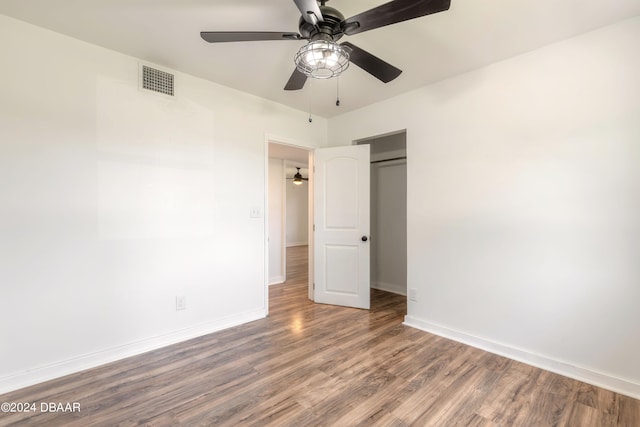 unfurnished bedroom with a closet, hardwood / wood-style flooring, and ceiling fan