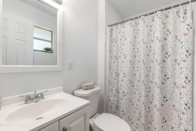 bathroom with toilet, vanity, and walk in shower