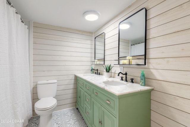 bathroom featuring wood walls, toilet, and vanity