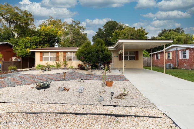 ranch-style house featuring concrete driveway, an attached carport, central AC unit, and stucco siding