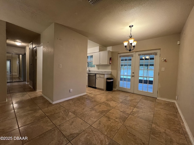 kitchen with french doors, light countertops, hanging light fixtures, white cabinets, and a chandelier