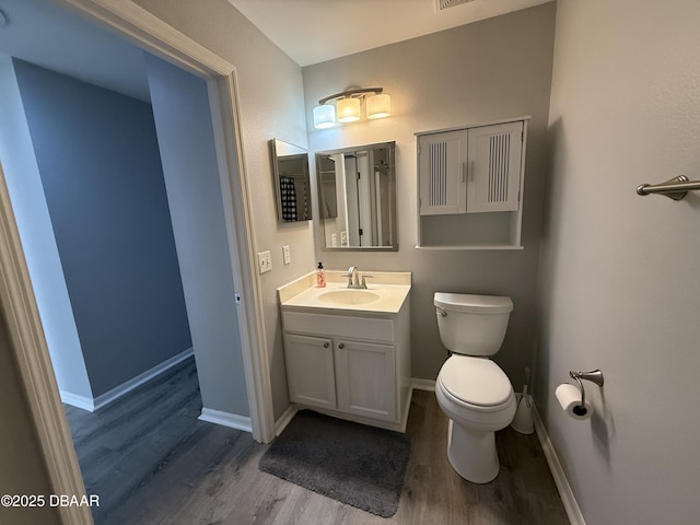 bathroom with hardwood / wood-style flooring, vanity, and toilet