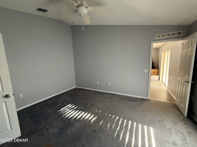 interior space featuring vaulted ceiling, ceiling fan, and dark carpet