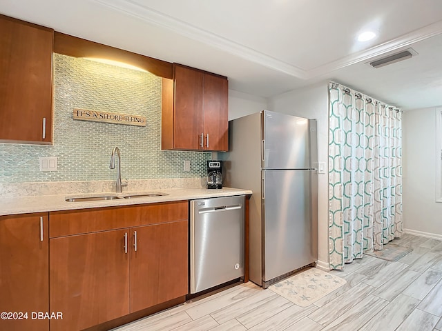 kitchen with backsplash, appliances with stainless steel finishes, sink, and light hardwood / wood-style floors