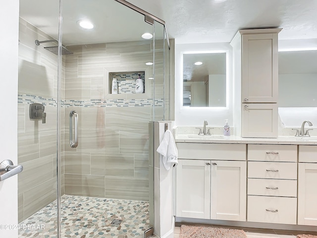 bathroom with vanity and a shower with door