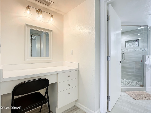 bathroom featuring walk in shower, vanity, and hardwood / wood-style floors