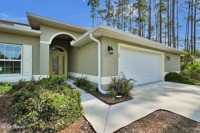 25 Egret Trl, Palm Coast, FL 32164 - property entrance featuring stucco siding, an attached garage, and concrete driveway