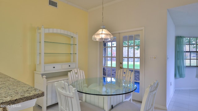 tiled dining space featuring ornamental molding and french doors