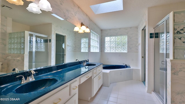 bathroom with tile patterned floors, vanity, a skylight, and independent shower and bath