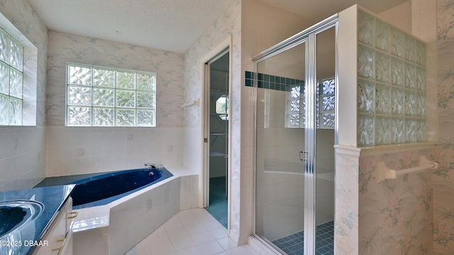 bathroom with a textured ceiling, tile patterned flooring, separate shower and tub, and vanity