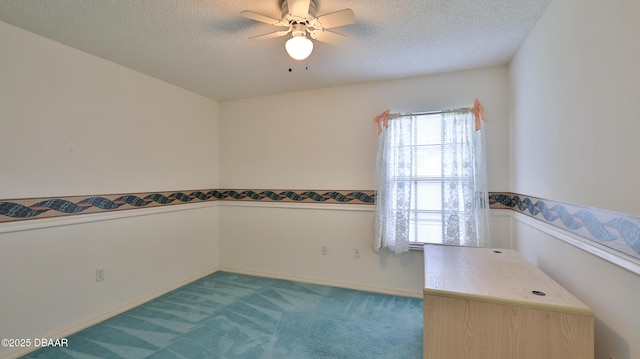 empty room with ceiling fan, light colored carpet, and a textured ceiling