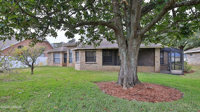 view of front facade featuring a front lawn and glass enclosure