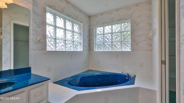 bathroom with vanity and a relaxing tiled tub