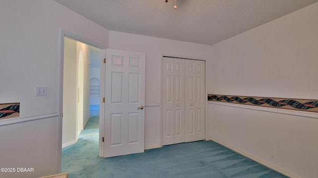 carpeted bedroom with a closet and a textured ceiling