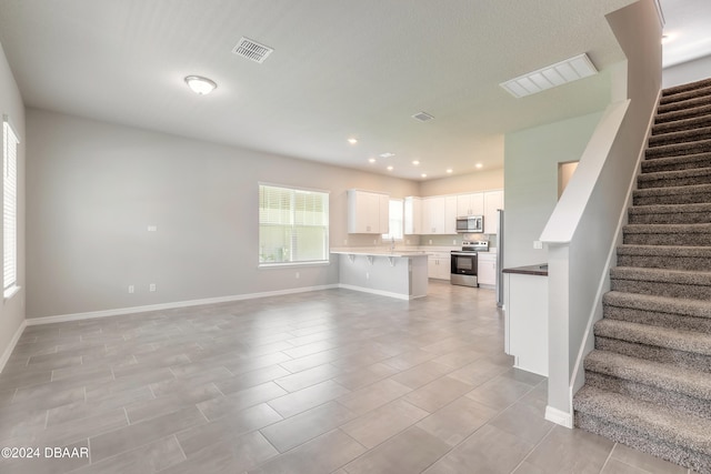 unfurnished living room with light tile patterned floors