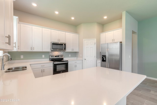 kitchen featuring stainless steel appliances, light hardwood / wood-style floors, white cabinetry, sink, and decorative backsplash