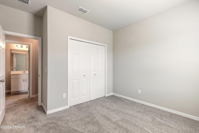 unfurnished bedroom featuring light carpet and a closet