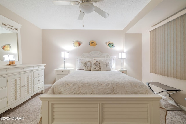 carpeted bedroom with ceiling fan and a textured ceiling