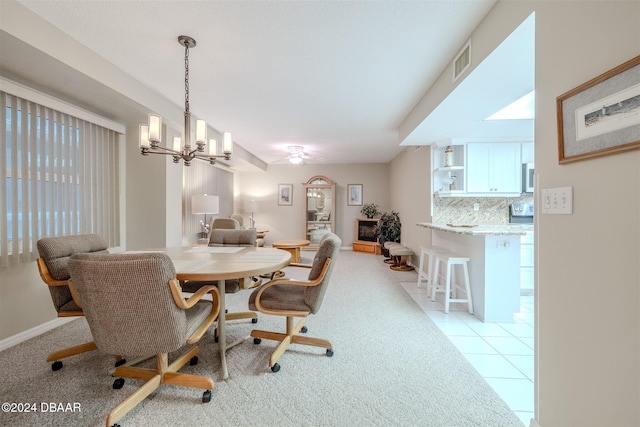 dining area featuring ceiling fan with notable chandelier and light tile patterned flooring