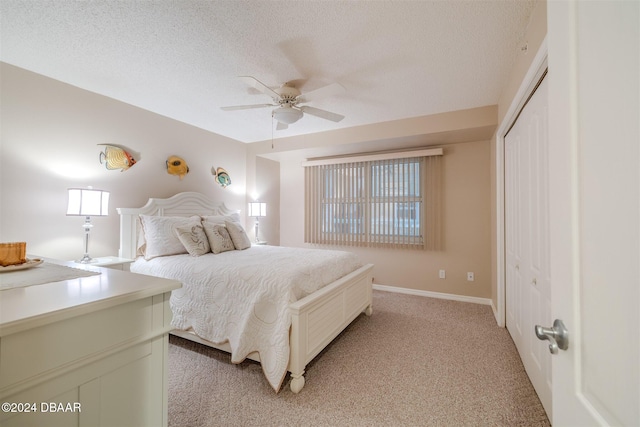 carpeted bedroom featuring ceiling fan, a closet, and a textured ceiling