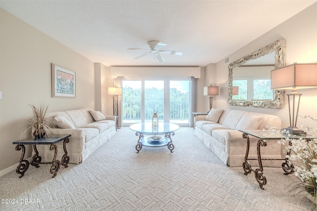 carpeted living room with a textured ceiling and ceiling fan