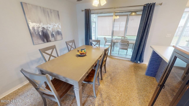 dining area with speckled floor, baseboards, and a ceiling fan