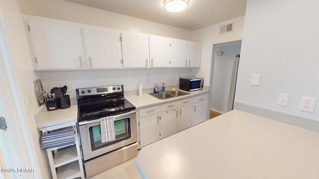 kitchen with visible vents, electric stove, a sink, white cabinetry, and light countertops