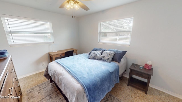 bedroom featuring multiple windows, light speckled floor, baseboards, and ceiling fan