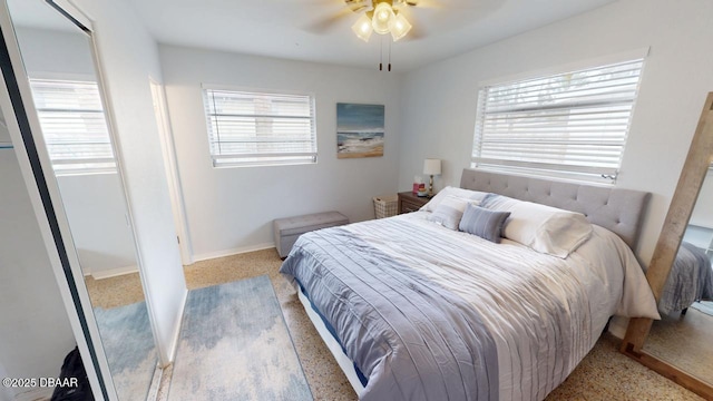 bedroom featuring speckled floor, multiple windows, baseboards, and ceiling fan