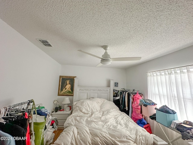 bedroom with ceiling fan and a textured ceiling