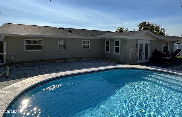 pool with french doors and a patio area