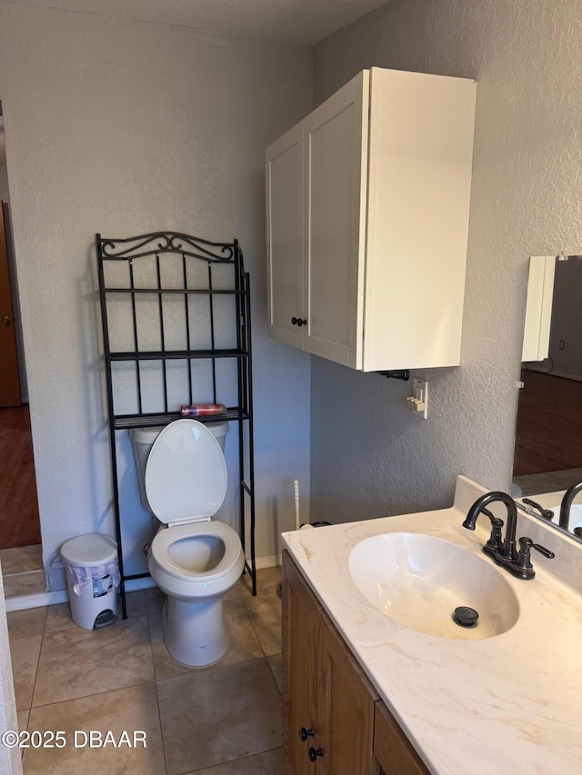 bathroom featuring tile patterned flooring, vanity, and toilet