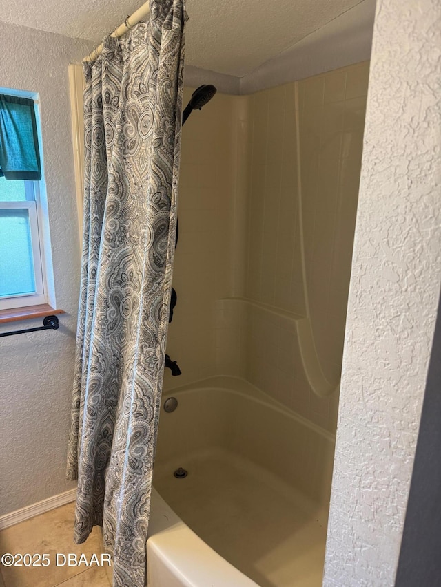 bathroom featuring tile patterned flooring, a textured ceiling, and shower / bath combo with shower curtain