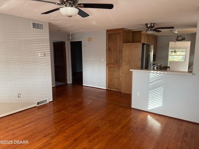 interior space with ceiling fan, dark hardwood / wood-style flooring, and a textured ceiling